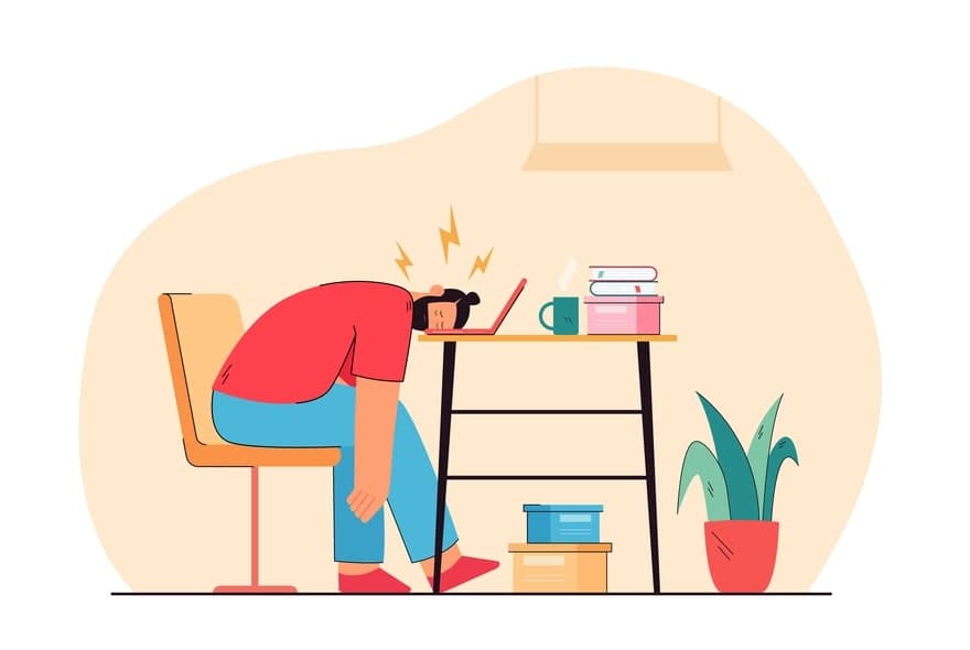 Person in red shirt sitting at desk with head in hand, experiencing back pain, surrounded by work materials and a potted plant